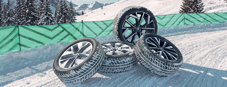 4 Winterreifen liegen im Schnee auf einem Haufen