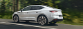Skoda Enyaq Coupé in weiß fährt schnell auf einer Straße im Wald (Skoda Auto Deutschland GmbH)