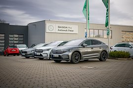 Mehrere koda-Fahrzeuge stehen vor dem Gebäude „koda Plus Autowelt Peter“. Zwei grüne Fahnen wehen im Vordergrund. Links im Bild parken weitere Autos. (Foto: Autohaus Peter)