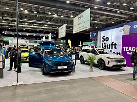 Ein blauer Peugeot und ein weißer Peugeot SUV nebeneinander auf der Ausstellungsfläche, im Hintergrund große Messebanner und lilafarbene Wand „So läuft Laden“. (Foto: Autohaus Peter Gruppe)