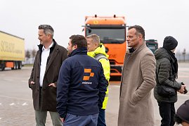 Gruppe von Männern in Winterjacken im Gespräch. Im Hintergrund ein Schade-Lkw. (Foto: ex animo MEDIA)