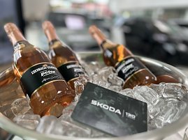 Drei Flaschen Sekt mit Etikett ‚Eberbach-Schäfer – Autowelt Peter – Alles Gute‘ liegen in einer Schale mit Eiswürfeln. Daneben eine Karte mit der Aufschrift ‚ŠKODA 130 Jahre‘.