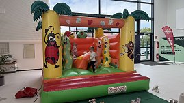 Kinder spielen auf einer bunten Hüpfburg mit Tier- und Insektenmotiven im Autohaus Autowelt Peter. Die Hüpfburg ist Teil des Familienprogramms zur Feier von 130 Jahren Škoda.
