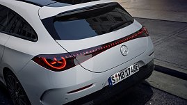 Das Bild zeigt einen weißen Mercedes-Benz CLA Shooting Brake, der auf einer breiten, nahezu leeren Stadtstraße fährt. Moderne Gebäude umgeben die Szene, das Licht wirkt weich und frühmorgendlich. Der Wagen ist seitlich zu sehen und vermittelt Dynamik sowie Eleganz.