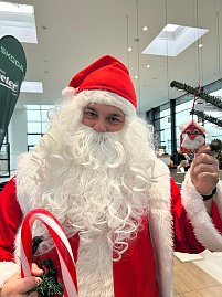 Der Weihnachtsmann hält einen Anhänger in die Kamera