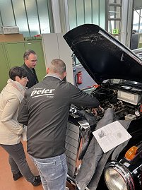 Serviceleiter Enrico Dost zeigt Besuchern, was unter der Motorhaube des Oldtimers "Adenauer" steckt.
