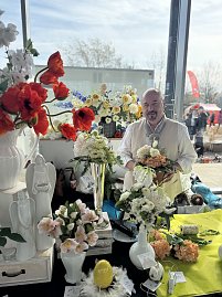 Dekorateur Frank Lüdtke hinter seinem Stand aus Kunstblumengestecken.