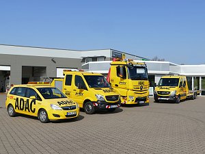 Vier gelbe ADAC-Servicefahrzeuge (ein PKW, zwei Transporter und ein LKW) stehen vor dem Gebäude des ADAC Mobilitätspartners Peter in Nordhausen auf einem gepflasterten Hof. Die Fahrzeuge sind mit ADAC- und Peter-Logos beschriftet. Im Hintergrund das moderne Werkstatt- und Bürogebäude.