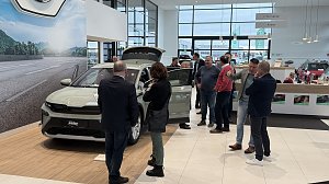 Der neue Škoda Elroq steht mit geöffnetem Kofferraum und Türen im Ausstellungsraum. Besucher stehen darum herum, einige sehen sich das Interieur an.