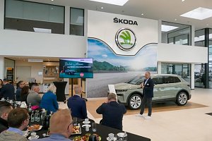 Ein Referent präsentiert den neuen Škoda Elroq vor Publikum. Der Bildschirm zeigt die Begrüßungsfolie. Gäste sitzen an Frühstückstischen.