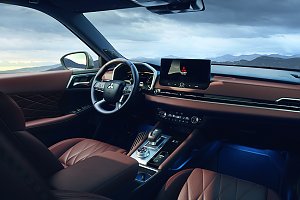 Innenraum mit Armaturenbrett: Moderner Innenraum des Mitsubishi Outlander mit braunen Ledersitzen, digitalem Display, großem Touchscreen in der Mitte und Blick auf eine Berglandschaft durch die Frontscheibe.