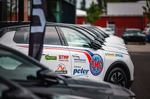 Nahaufnahme einer Reihe weißer Opel-SUVs mit schwarzem Dach, die nebeneinander auf einem Parkplatz stehen. Auf der Fahrertür des vordersten Fahrzeugs sind zahlreiche Logos zu sehen, darunter THC Thüringer Handball Club, Autohaus Peter, TMP Fenster + Türen, Joma, Universal Bau und weitere.
