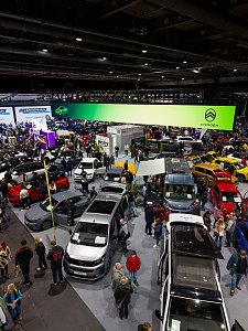 Große Automesse mit vielen Fahrzeugen und Besuchern.