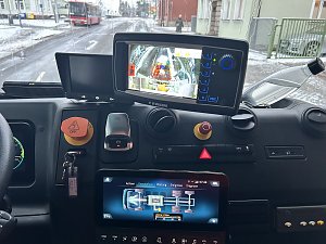 Blick in das Cockpit eines Müllfahrzeugs mit Monitoren und Bedienelementen zur Fahrzeugsteuerung.
