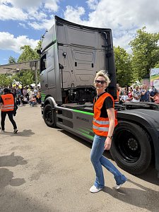 Kati Bergmann, Serviceassistentin in Bernburg, l&auml;uft als Radengel in orangener Warnweste neben dem eActros.