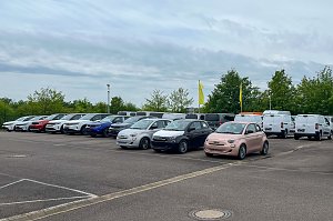 Der gro&szlig;e asphaltierte Au&szlig;enparkplatz des Autohauses Peter in Halle Neustadt/ G&ouml;ttinger Bogen mit zahlreichen aufgereihten Fahrzeugen. Darunter zum Beispiel drei Fiats im Vordergrund.