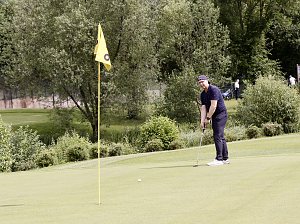 Golfer konzentriert sich auf einen Putt nahe der Fahne auf einem gepflegten Grün.