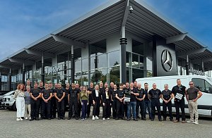 Das Service-Team aus Dessau steht vor dem Mercedes-Benz Center. Zwei Kollegen halten die Auszeichnung in den H&auml;nden. Im Hintergrund sind Autos zu sehen.