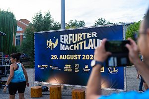 Veranstaltungsfläche des Erfurter Nachtlaufs 2026 mit großem Veranstaltungsbanner und Siegerpodest.