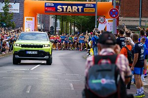 Grüner Jeep Compass der Autohaus Peter Gruppe als Führungsfahrzeug vor dem startenden Läuferfeld beim Erfurter Nachtlauf 2026
