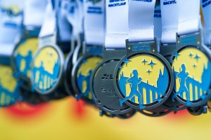 Finisher-Medaillen des Erfurter Nachtlaufs 2026 mit Läufermotiv und Erfurter Stadtsilhouette