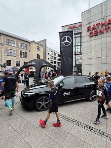 Man sieht einige Teilnehmer, im Fokus des Bildes steht der CLA Shooting Brake in Schwarz, dahinter eine große schwarze Fahne mit dem weißen Mercedes-Benz Stern und dahinter der schwarze, aufblasbare Mercedes-Benz Pavillon.