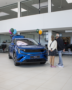 Zwei Besucher betrachten den blauen �koda Peaq, der mit bunten Luftballons im Showroom der Autowelt Peter ausgestellt ist.