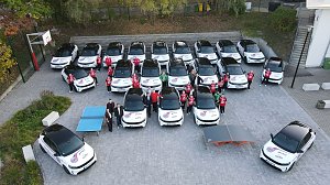Drohnenaufnahme der Opel-Fahrzeugflotte im Thüringer-HC-Design, aufgestellt in mehreren Reihen mit Spielerinnen und Verantwortlichen dazwischen.