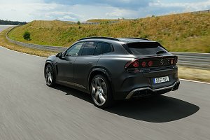 man sieht einen vollelektrischen AMG GT aus dem SUV-Segment. Er fährt auf einer Straße und man erkennt die Hinterseite des Fahrzeugs.