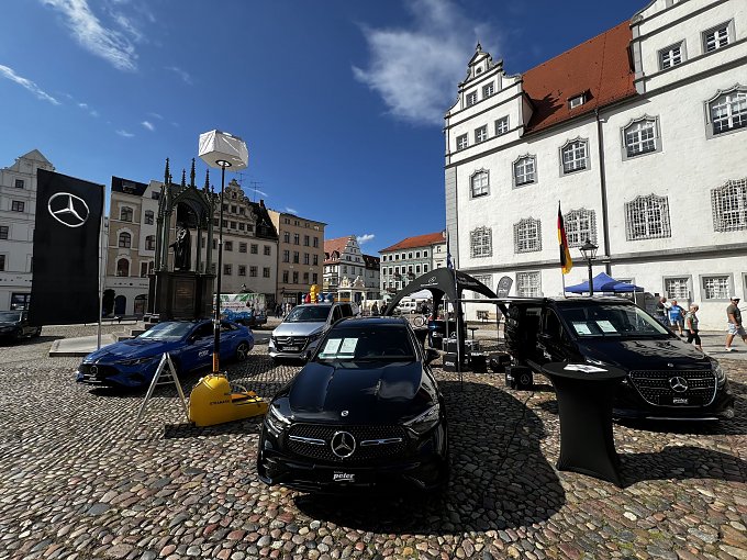 Zu sehen ist der Stand vom Autohaus Peter auf dem Marktplatz in Wittenberg. Des weiteren sind 4 einzelne Modelle von Mercedes-Benz zu sehen.  