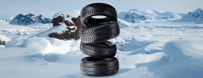 4 gestapelte Winterreifen in Winterlandschaft